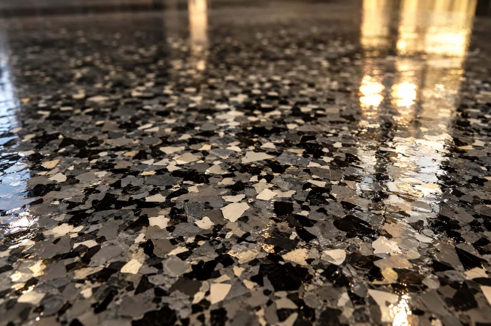 Close-up of gray and white flake chips under a clear gloss topcoat